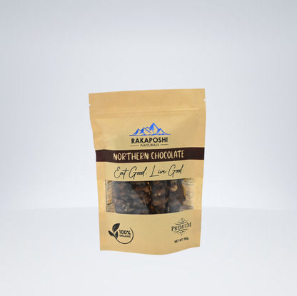 A packaged product labeled 'Rakaposhi Naturals Northern Chocolate', featuring walnut pieces visible through the clear packaging, with the brand's logo and product details.
